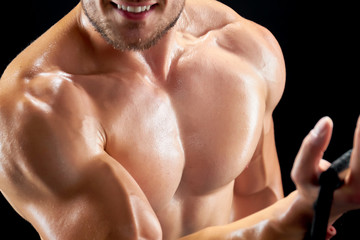 Cropped shot of training sportsman. Close view on chest and biceps. Sweat and intensity.