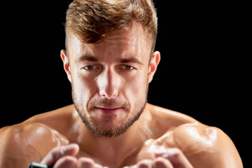 Obraz premium Tired sportsman during a workout. Studio portrait of young man on black. Hard work to build a perfect body.