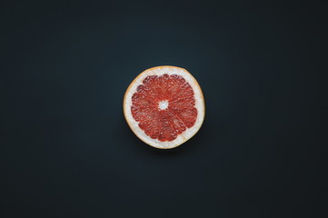 One grapefruit on dark background. Single slice of pomelo.