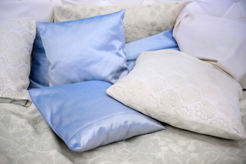 Fototapeta na wymiar Pillow satin pile. Bed for relaxation. Bedding accessories for sleep. Pillows bedding colorful.