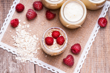 Jars with yogurt, raspberries and oat flakes 