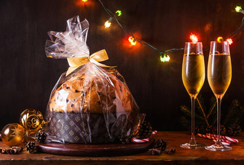 Italian festive bread panetton with a transparent wrapper on a table decorated for Christmas. and...