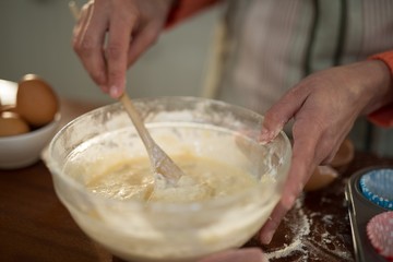 Obraz na płótnie Canvas Woman mixing eggs and wheat flour in a bowl