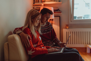 Obraz premium Christmas gifts and happiness between a young couple and a cute dog