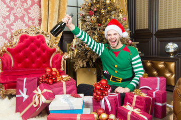 Obraz na płótnie Canvas Macho in elf costume smile with champagne bottle