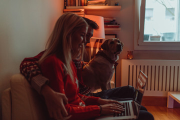 Obraz premium Christmas gifts and happiness between a young couple and a cute dog