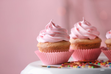 Dessert stand with delicious cupcakes on blurred background, closeup