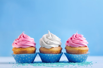 Delicious cupcakes on color background
