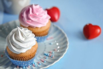 Plate with delicious cupcakes on table, closeup