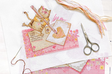 Cross-stitch set : embroidery with cat pattern , scissors, canvas and colorful yarn. View from...