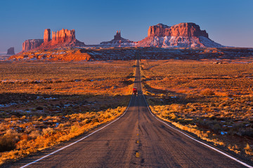 A road leading to Monument Valley with red truck going at camera, Usa