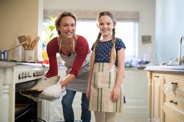 Obraz premium Mother and daughter preparing cup cake in kitchen