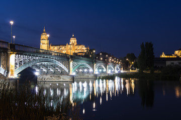 Night view of Salamanca Old and New Cathedrals from Enrique Esteban Bridge over Tormes River, Community of Castile and Leon, Spain.  