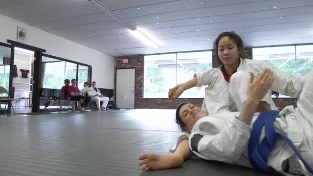 Young women practicing Jiu-jitsu in a dojo
