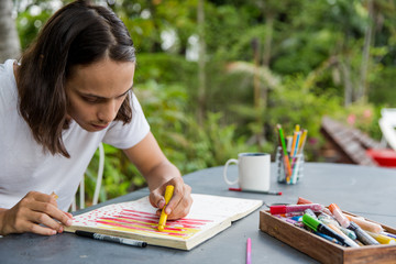 Young artist drawing in his notebook