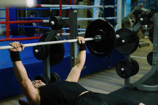 Close-up of a man holding his hands with a barbell for pulling, squatting, fitness in the gym. Concept sports, toned picture, copyspace for text