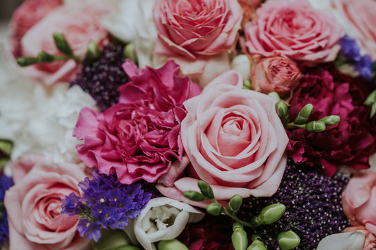 Pink roses and other various flowers wedding bouqet closeup background.