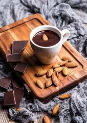 Hot chocolate with almonds on a wooden board