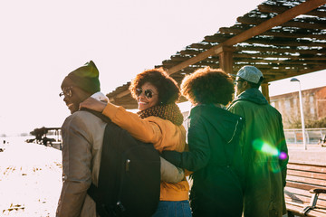 Back view of 4 black race friends walking in the city