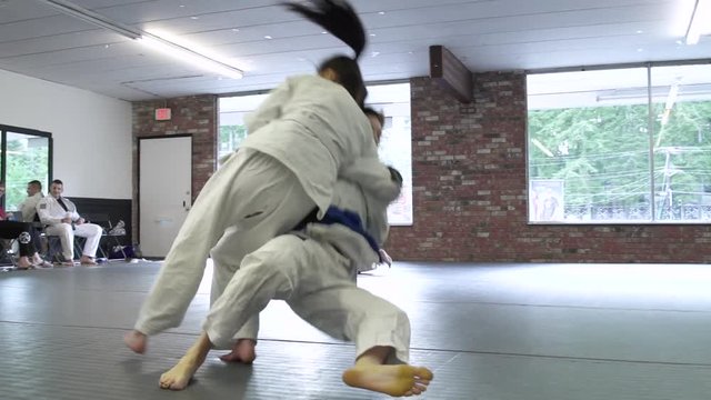 Young people practicing Jiu-jitsu in a dojo