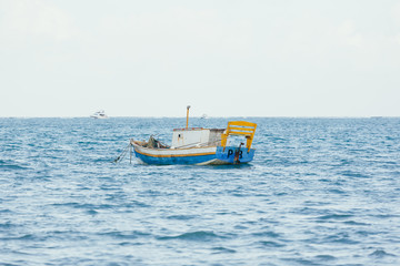Obraz premium A little wooden boat floating in the sea