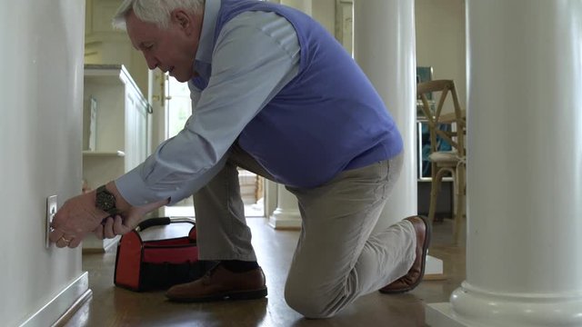 Senior man repairing a socket