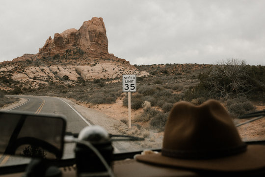 speed limit sign on side of road seen through windshield