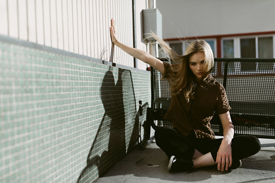 Woman Model Outdoors Sitting on The Ground Hair Blowing in The Wind