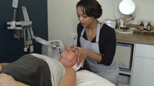 Young woman getting a facial treatment in a spa