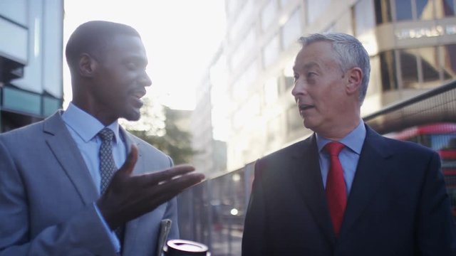 Two business men walking and talking in the street