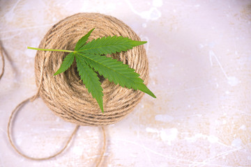 Macro detail of hemp fiber twine and cannabis leaf - marijuana hemp concept