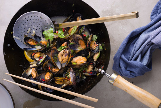 Steamed mussels in a wok with chilli,garlic,coriander and spring onion.