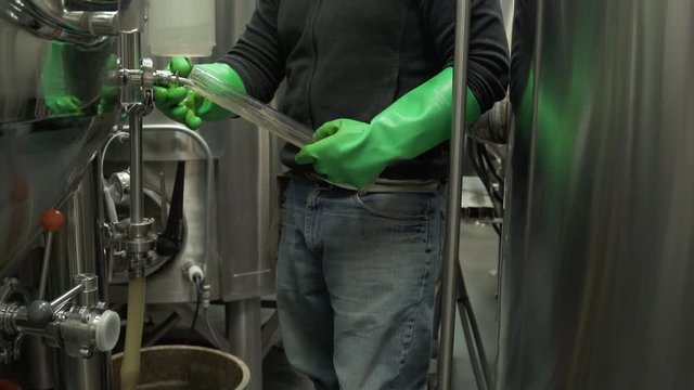 Woman pulling a pallet jack full of beer kegs