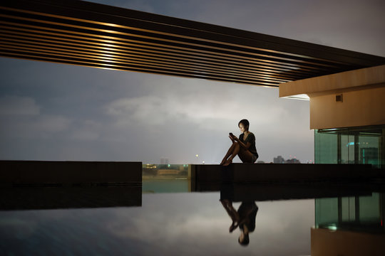 Woman using cellphone at pool