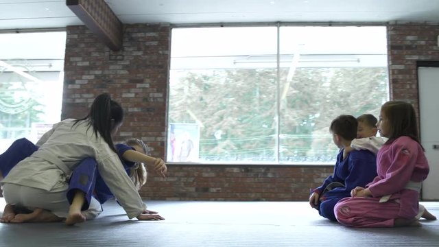 Teenage girls teaching Jiu-jitsu moves for children