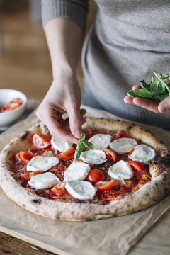 Woman cooking homemade pizza
