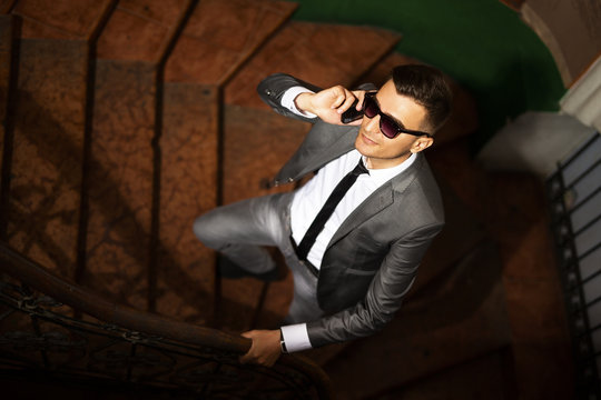 Young businessman on a stairs talking on a smartphone