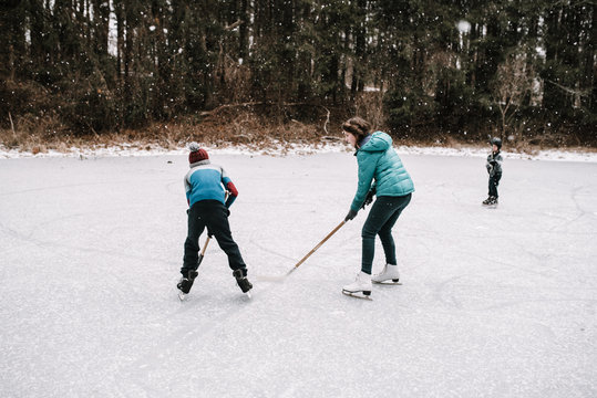 kids playing hockey on frozen pond