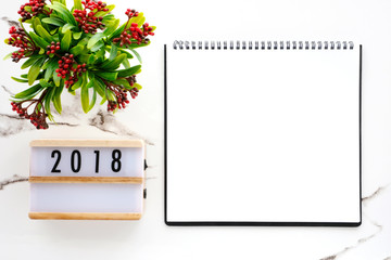 2018 on wood box and blank notebook paper on white marble table background, 2018 new year mock up, template with copy space for text, top view