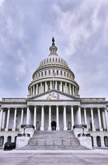 Fototapeta premium Capitol Building facade and empty plaza on a dark cloudy day with two secret service vehicles parked, but no people visible, Washington D.C., USA