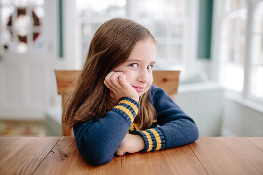 Cute young girl smiling at table