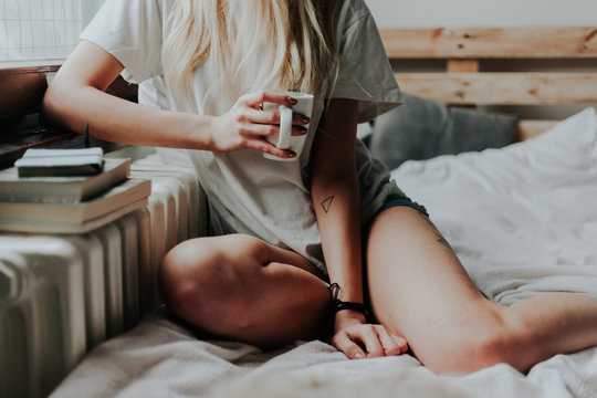 Young tattooed woman holding a cup of coffee