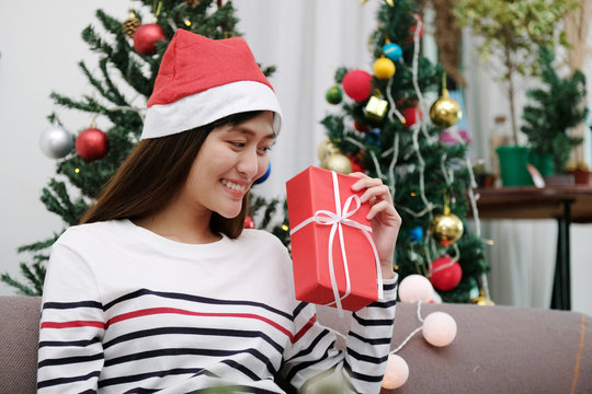 Young cute asia woman smiling and holding Christmas  red gift box at Christmas party, Christmas people holiday celebration concept