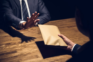 Businessman rejecting money in the envelope