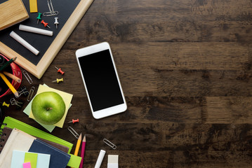 Stationery, education supplies and learning equipment including smartphone on wood table background