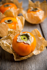 Fresh persimmon fruit on wooden table. Selective focus. Shallow depth of field.
