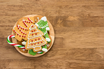 Christmas gingerbread cookies and candy cane on wood background