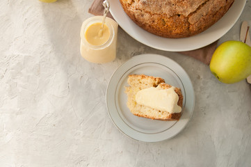Slice of Irish apple pie on a white plate with vanilla custard sauce. Festive dessert for St.Patricks Day.