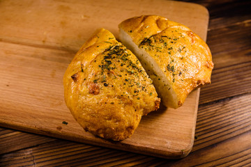 Italian bun ciabatta with garlic on wooden table