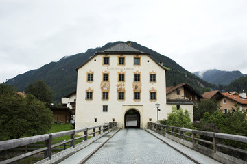 Old tower house and old bridge over Bad inn river for travelers people walking and travel at Pfunds village in Tyrol, Austria
